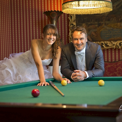 Photo de couple de mariés fun sur un billard