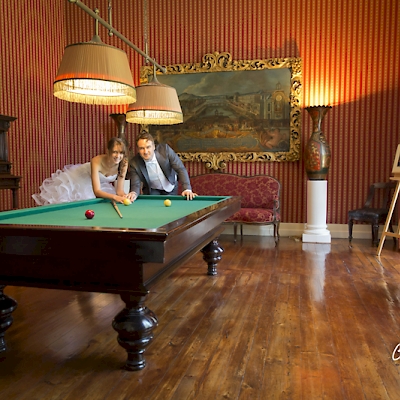 Photo de couple de mariés fun sur un billard