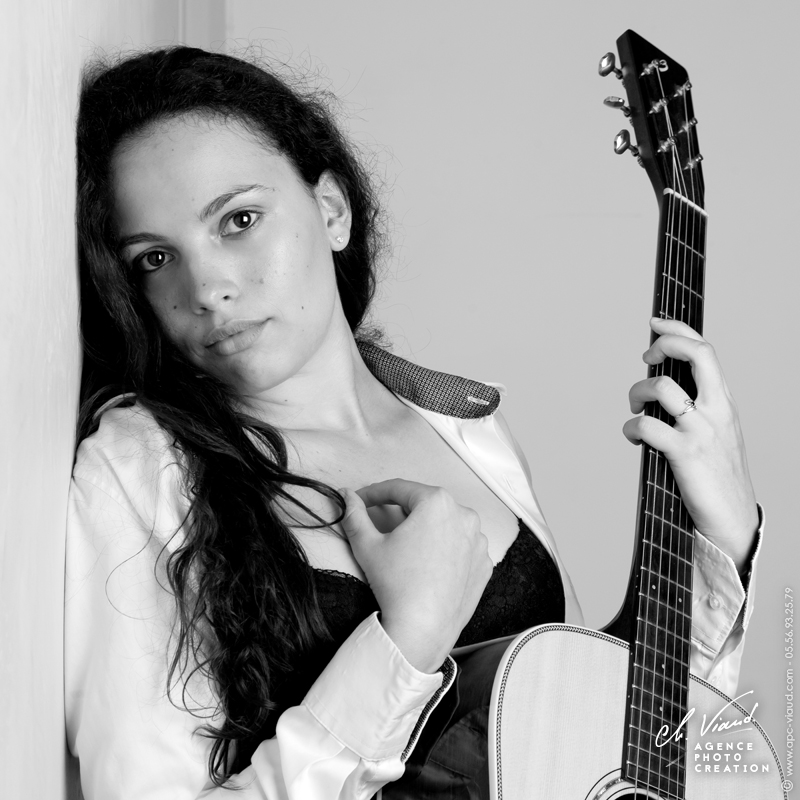 Portrait glamour d'une femme en lingerie avec sa guitare