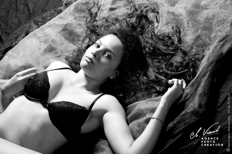 Joli portrait d'une femme en lingerie allongée dans un studio photos