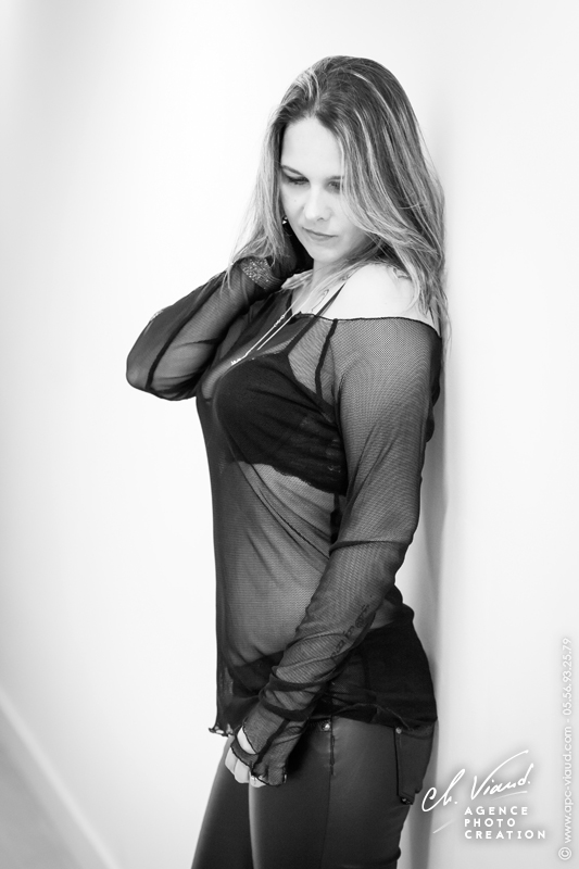 Photo sexy d'une femme de plein pied avec un haut transparent dans un studio