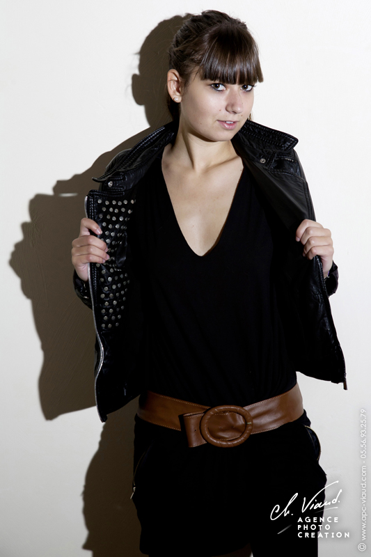 Portrait studio sur fond blanc d'une jeune femme avec une robe et une veste en cuir