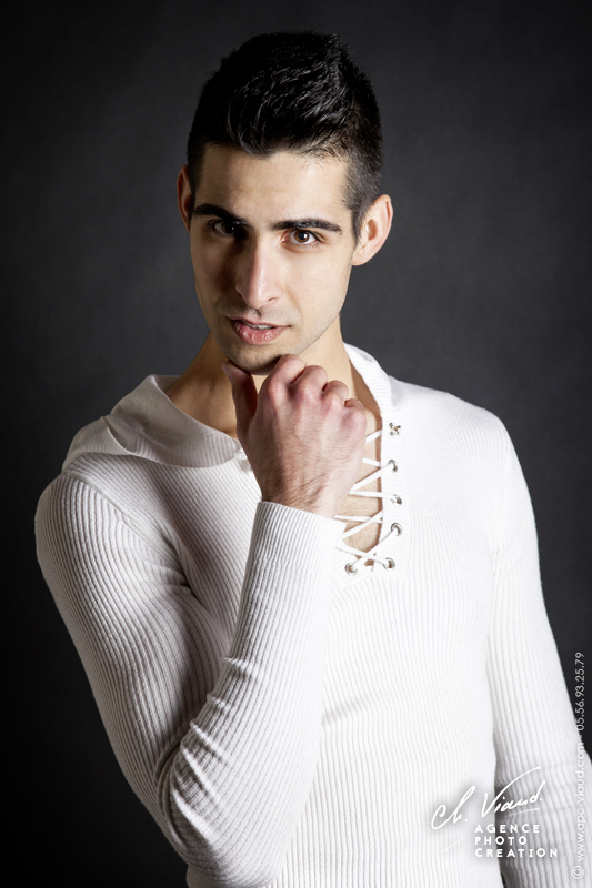 Portrait studio d'un homme avec un pull blanc