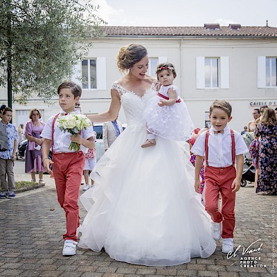 Reportage mariage - Photo de la mariée avançant vers la mairie avec ses enfants d'honneur